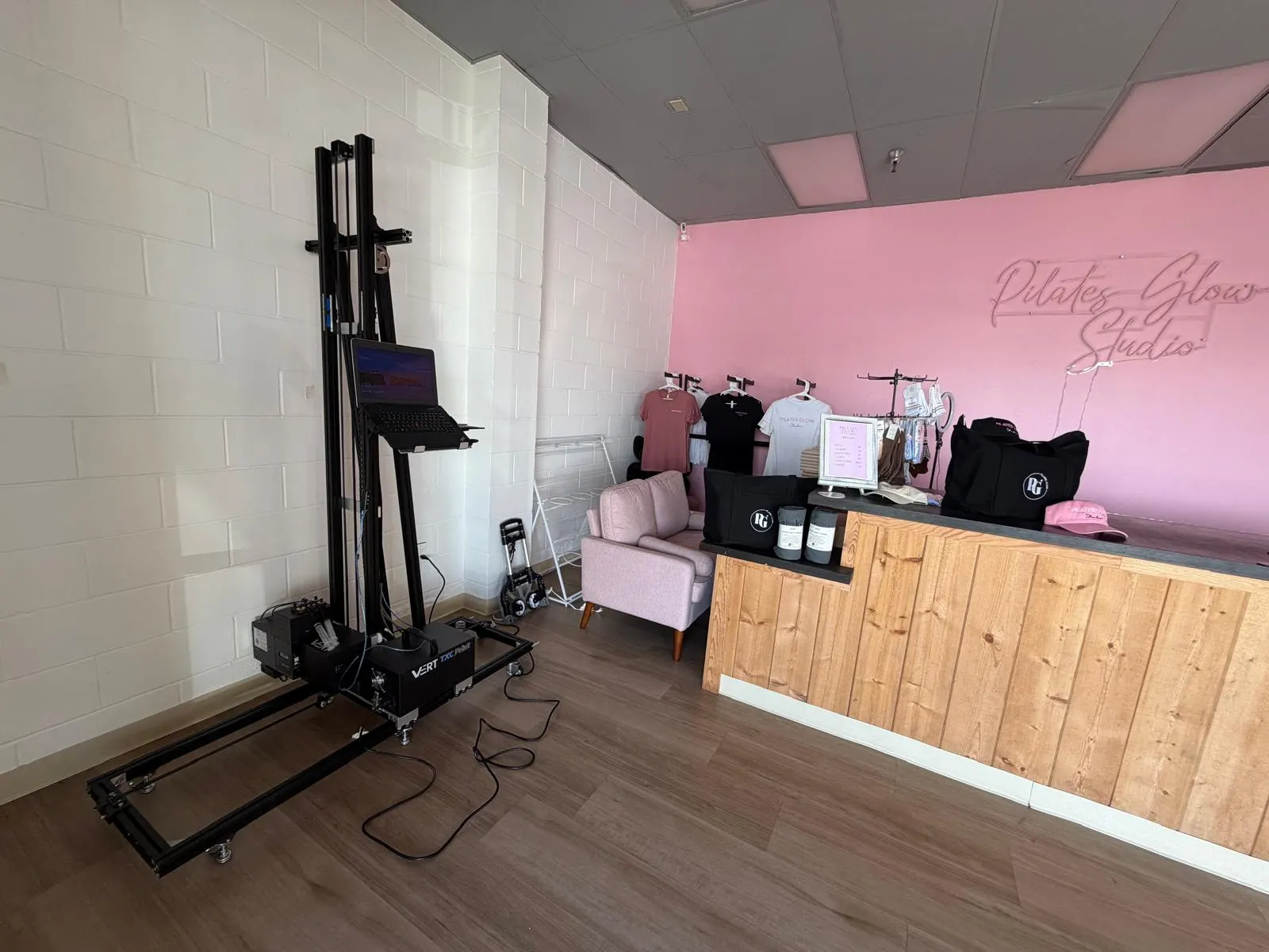 The VERT wall printer set up in a studio beside a pink wall